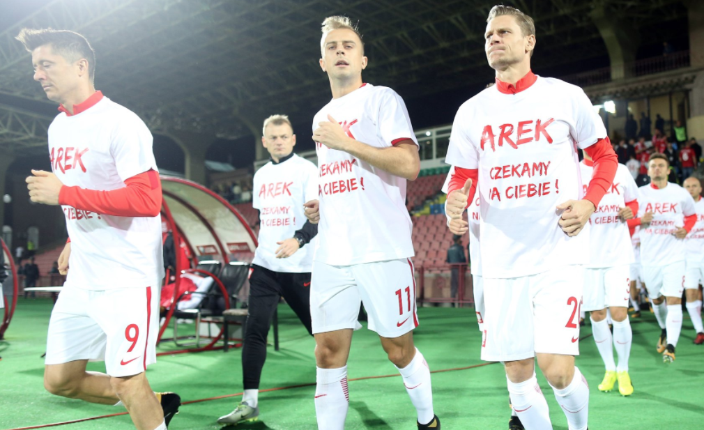 Calciatori della Polonia in campo con la maglia per Milik