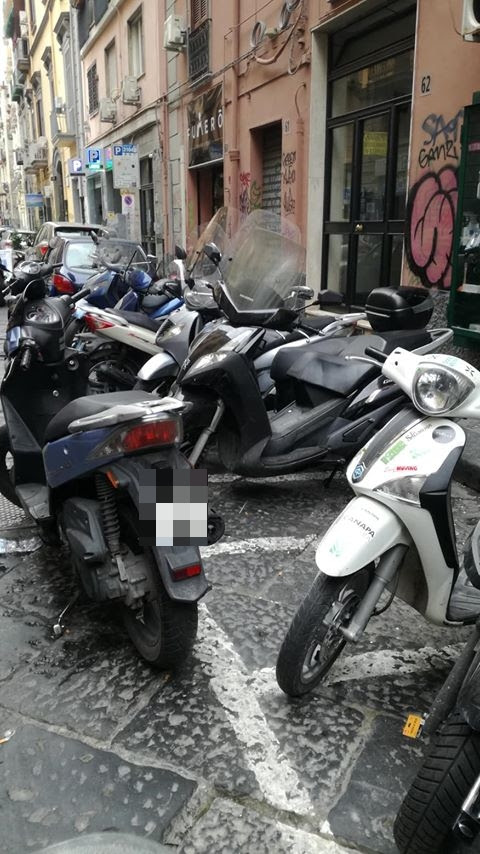 Napoli, via Sedile di Porto, la nuova trovata dei parcheggiatori abusivi: scooter di traverso per estorcere soldi a chi lascia il motorino