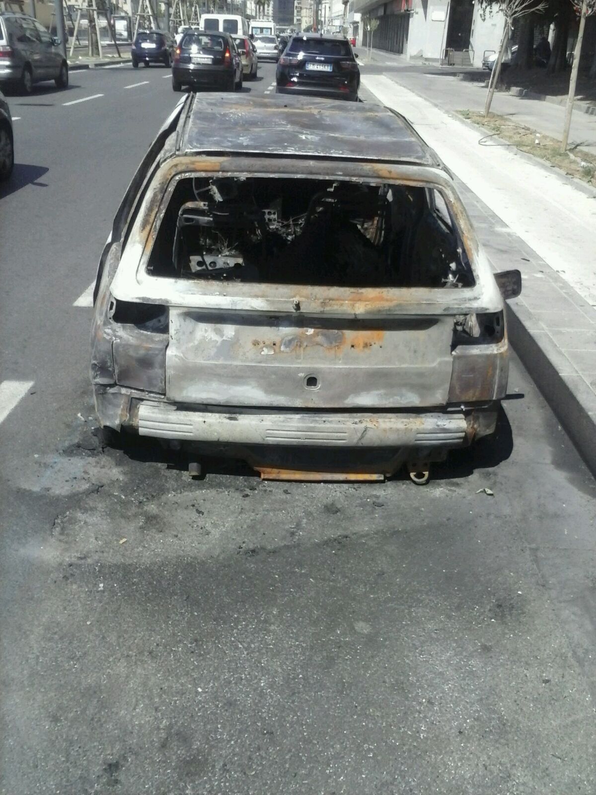 Napoli, il caso dei clochard davanti all’ospedale finisce sulle tv nazionali e l’auto incendiata è ancora lì