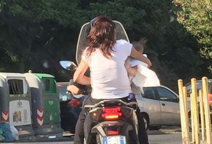 Napoli, giovane mamma in sella allo scooter con la neonata in braccio: la foto virale sul web
