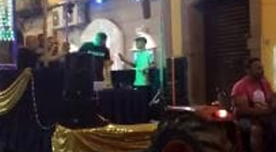 Un cantante neo melodico in giro col trattore durante la festa patronale: polemiche sui social