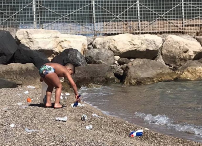Castellammare, un bambino ripulisce una spiaggia dai rifiuti e dalle cicche lasciate dagli adulti
