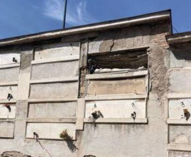 Napoli, loculo aperto e scheletro in bella mostra all’ingresso del cimitero di Poggioreale