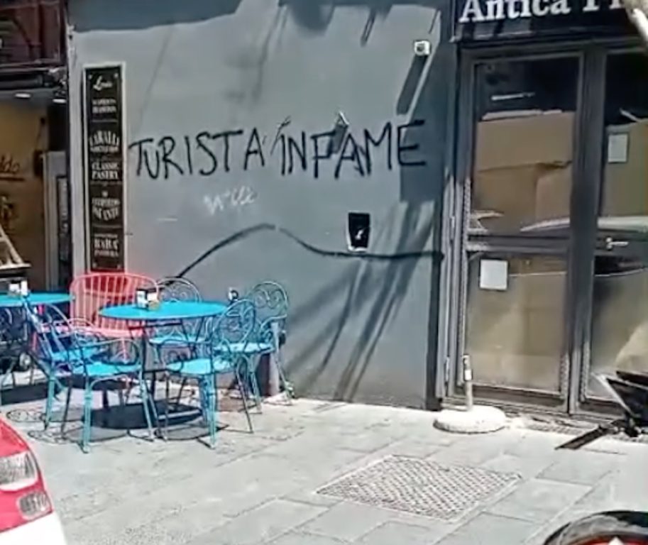 A Napoli scritta contro i turisti sui muri del centro storico, giovane napoletano si offre di ricoprirla a sue spese