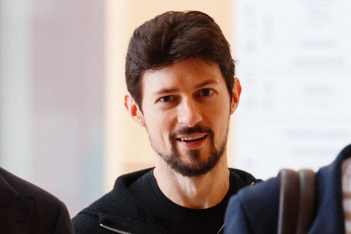 Un uomo con un telefono mostra un messaggio su un'applicazione, mentre un'immagine di un logo di Telegram appare in primo piano