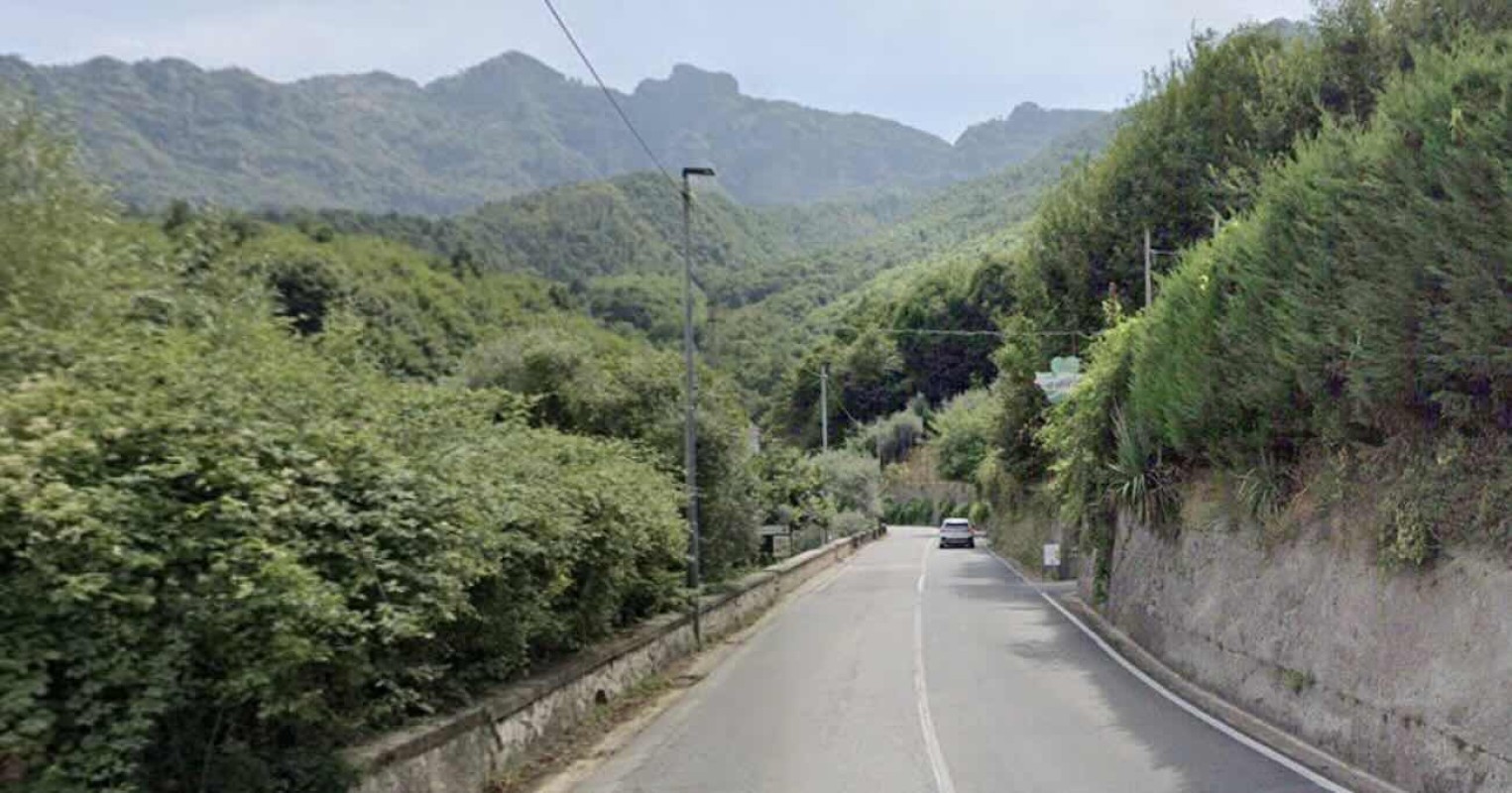 Via cittadina con segnaletica stradale, veicoli coinvolti in incidente, mezzi d'emergenza